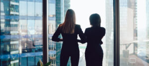 Women Business Partners looking out conference window