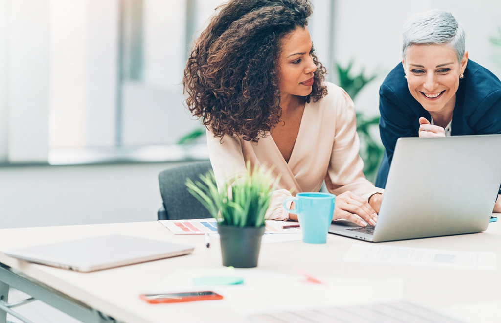 Business partners working on 1 laptop