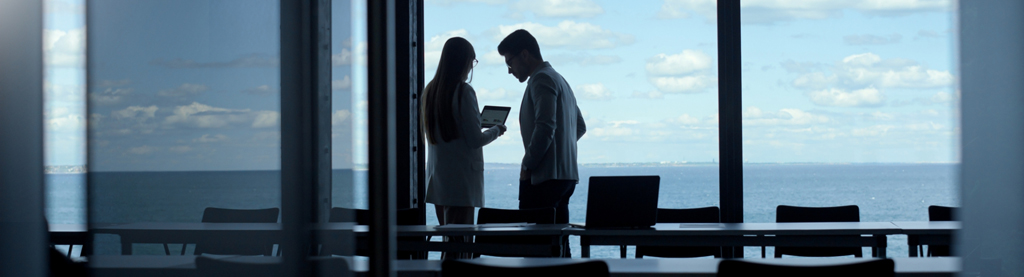 Two business partners making plans on the balcony by the sea