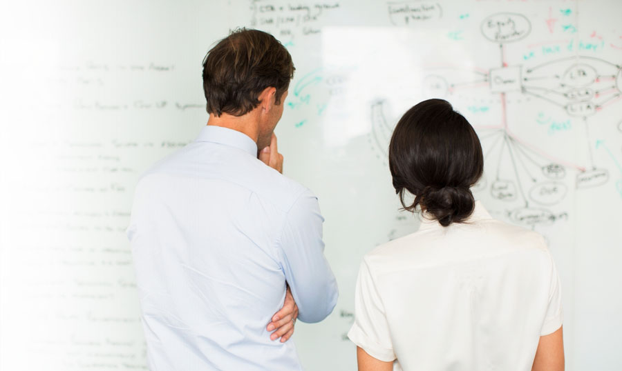 Business Partners Using White Board to Analyze and Plan