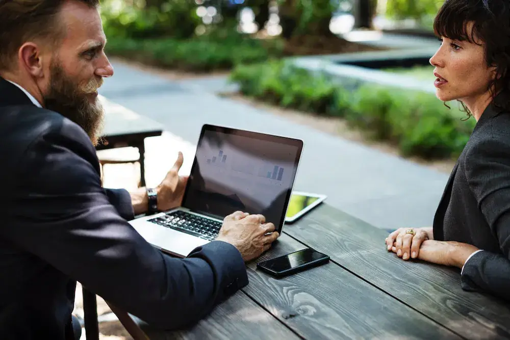 business-partners-in-a-tense-meeting Two business partners sitting across a table from each other, neither speaking