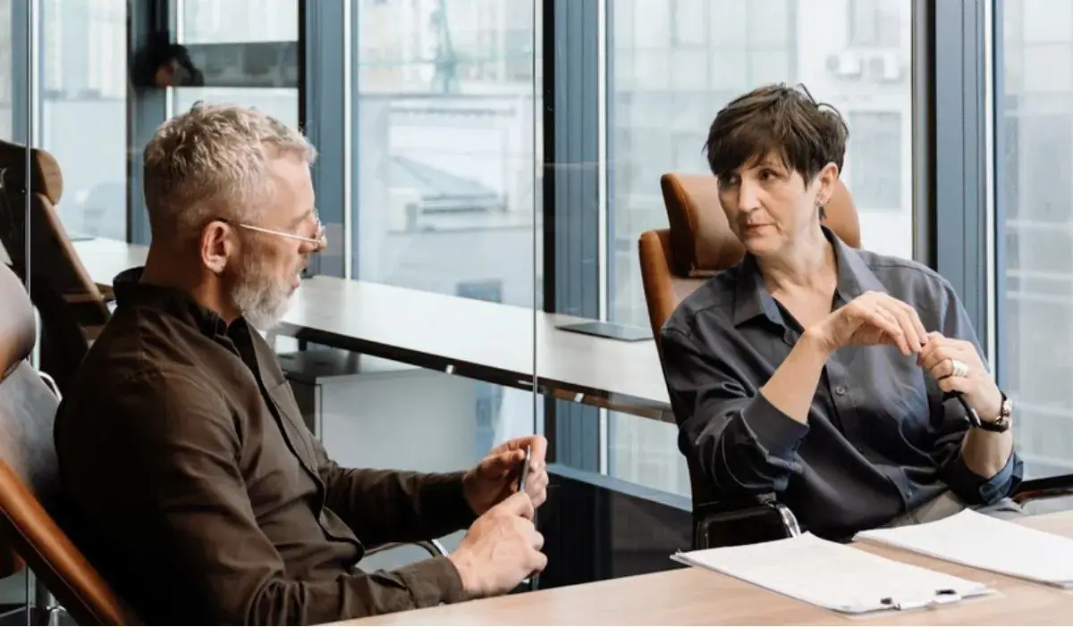 Two business partners at a boardroom table without a decision between them