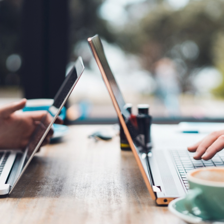 cofounder business partners with laptops against each others