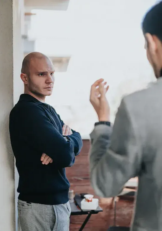 SS Home P2 Two business partners standing in a tense exchange, one with arms folded